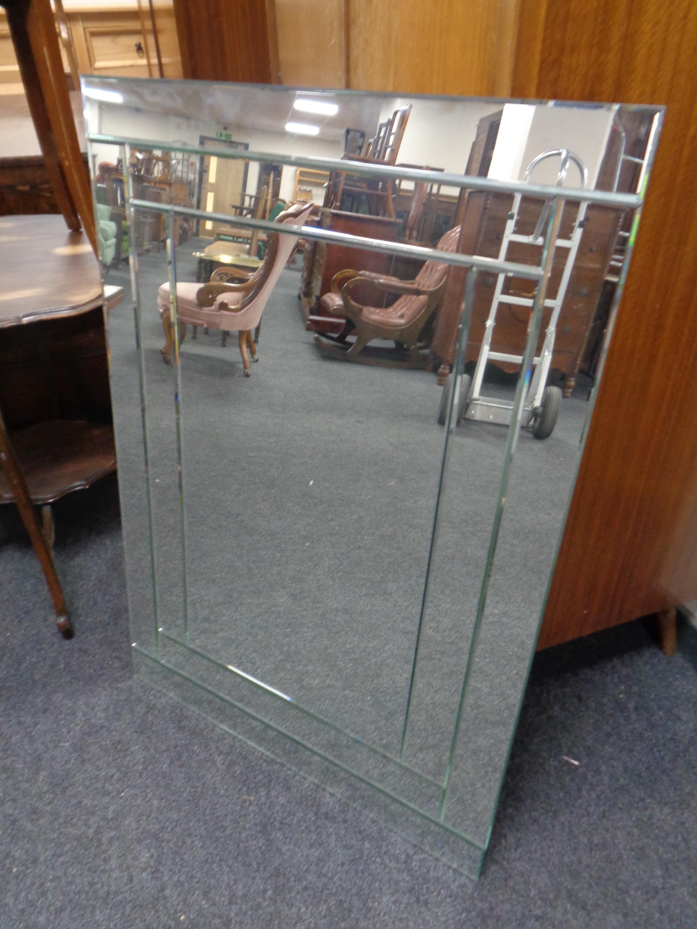 A contemporary all glass bevelled mirror