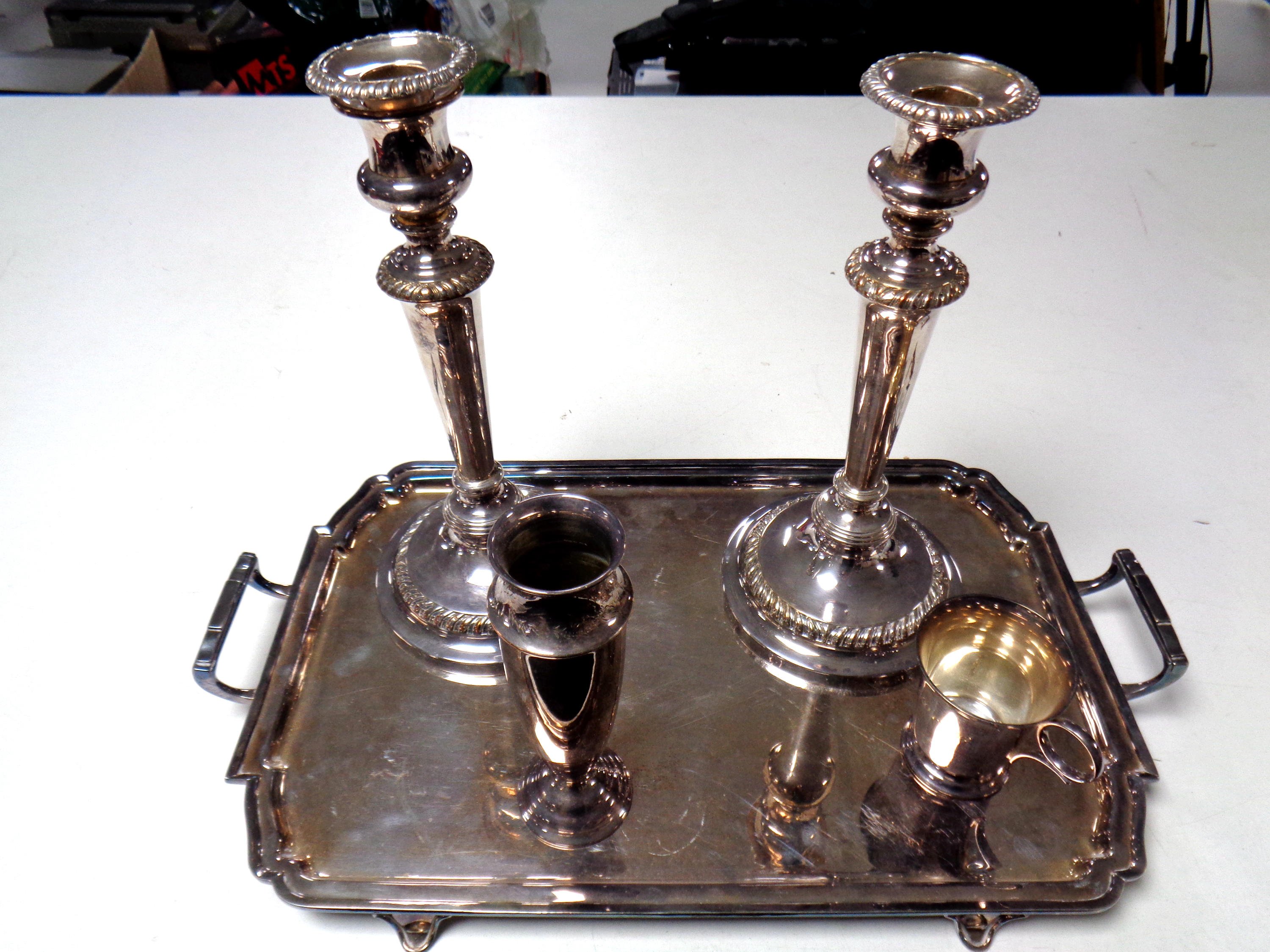 A silver plated Art Nouveau serving tray together with a pair of plated candlesticks,