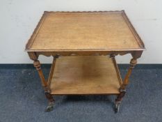 A 20th century oak two tier tea trolley together with a Victorian mahogany dressing table mirror