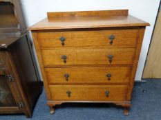 An Edwardian oak chest of four drawers on pad feet