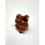 A carved hardwood Chinese netsuke - Two rabbits