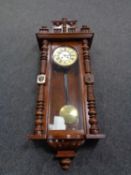 An early 20th century mahogany cased Vienna style eight day wall clock with pendulum and key