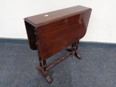 An inlaid mahogany drop leaf table on brass capped feet