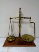 A set of antique brass pan scales with weights mounted on a board