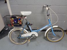 A folding lady's Universal bike with tin containing bike accessories