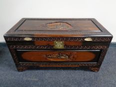 An oriental carved camphor wood blanket chest