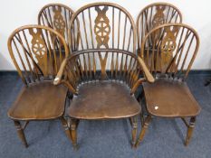 An elm Windsor armchair and a set of four further matching chairs