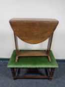 A small oak drop leaf table together with a stool in green dralon upholstery