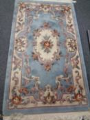 A Chinese floral embossed fringed rug on blue ground