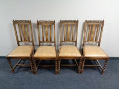 A set of four Edwardian carved oak dining chairs on barley twist supports