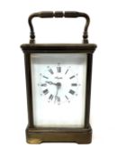 A brass cased eight-day carriage clock by Angelus, height 17 cm, complete with brass winding key.