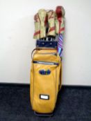 A 20th century leather golf bag on folding trolley containing a set of Royale irons and Nicoll