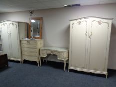A four piece cream and gilt French style bedroom suite comprising pair of double door wardrobes,