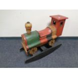 A wooden child's rocking toy in the form of a train