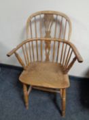 An antique elm Windsor kitchen armchair