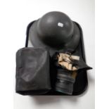 A WWII tin helmet together with two gas masks