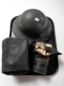 A WWII tin helmet together with two gas masks