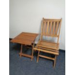 A folding teak ship's style chair with similar occasional table