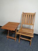 A folding teak ship's style chair with similar occasional table