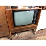 A mid 20th century Dynatron television in teak cabinet with shutter door