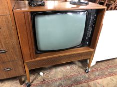 A mid 20th century Dynatron television in teak cabinet with shutter door