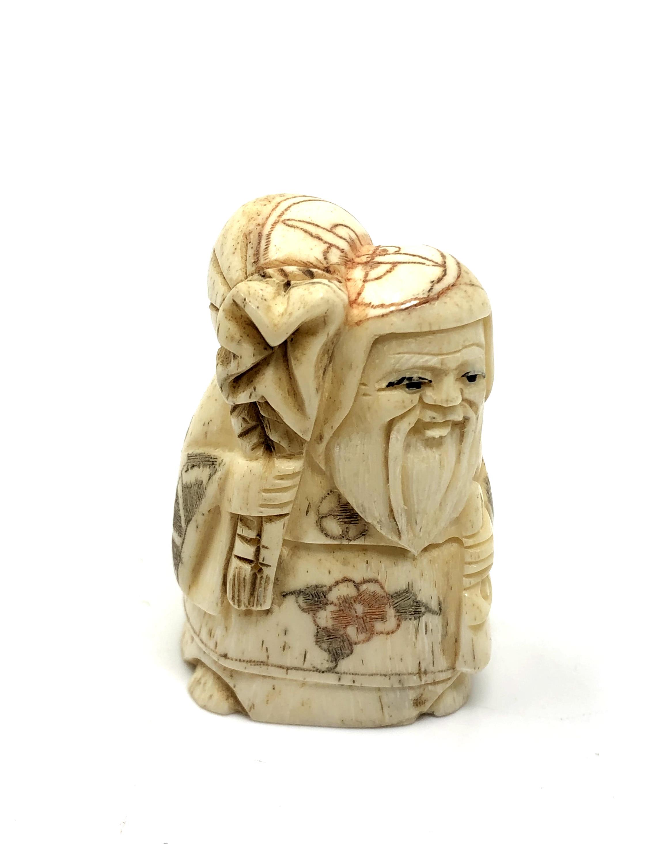 A carved bone netsuke - Bearded man with sack