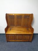 A 20th century oak Gothic style storage settle