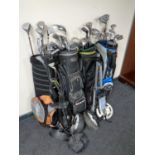 Four golf bags containing a large quantity of golfing irons and drivers to include Howson,