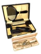 A cased dressing table set, together with a box containing costume pearls,