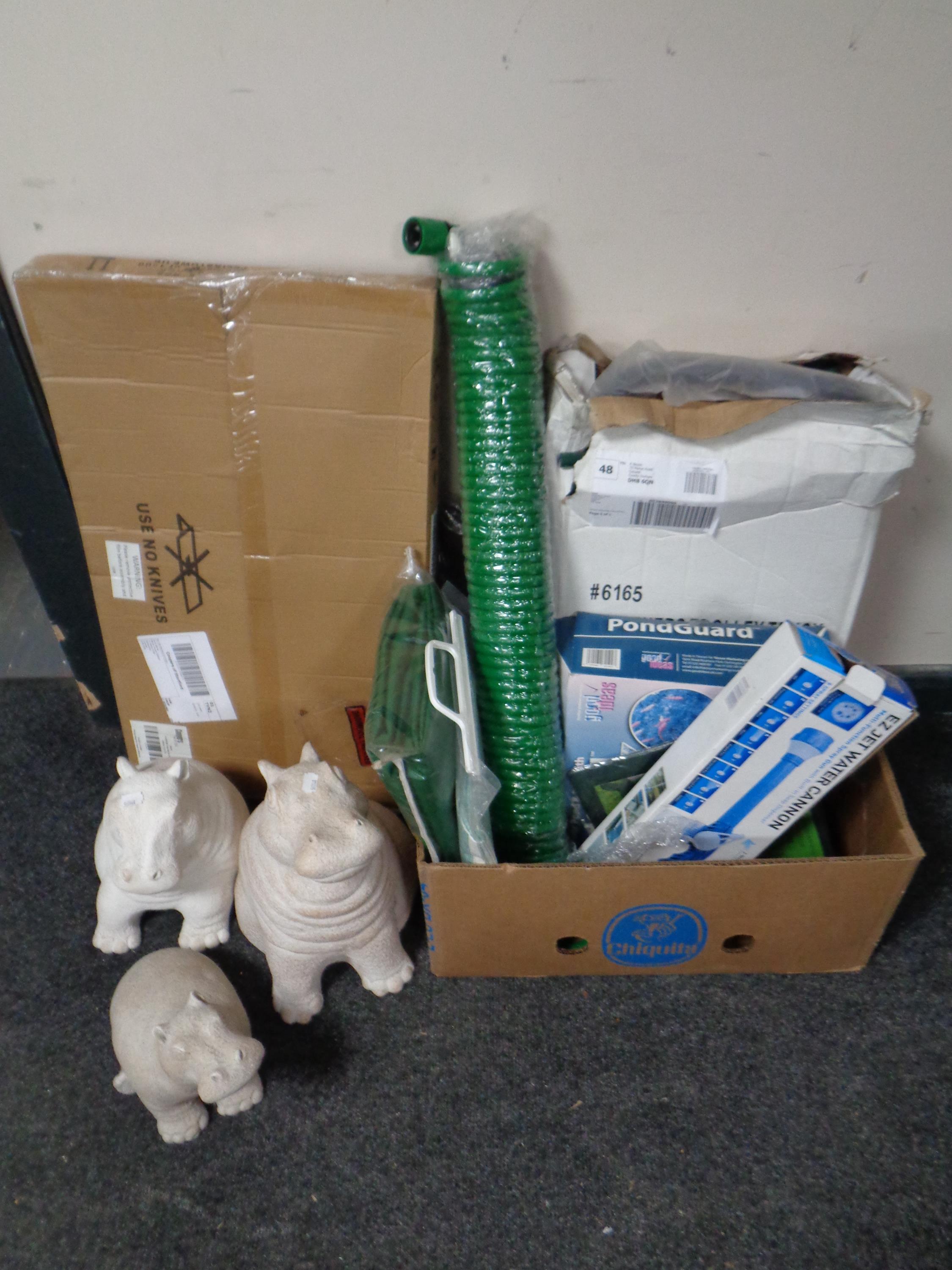 A box of new gardening equipment to include coil hose, water cannon, fish pond protector,