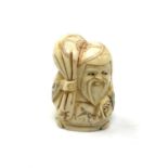 A carved bone netsuke - Elderly man carrying money bag