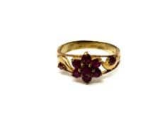 A ruby cluster ring on yellow metal shank,