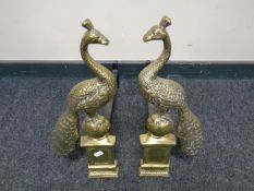 A pair of Art Nouveau style brass peacock fire dogs