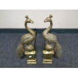 A pair of Art Nouveau style brass peacock fire dogs