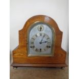 An Edwardian oak cased mantel clock with silvered dial on raised brass feet CONDITION