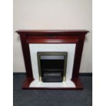 An electric fire place with mahogany surround and faux marble hearth and back
