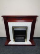 An electric fire place with mahogany surround and faux marble hearth and back