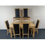 A light oak kitchen table together with a set of six high back chairs