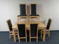 A light oak kitchen table together with a set of six high back chairs