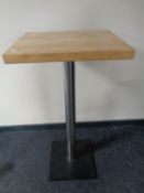 A pine topped poser bar table on metal pedestal