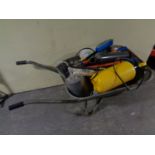 A wheelbarrow containing garden sprayers,