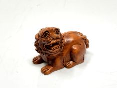 A carved hardwood netsuke - Lion