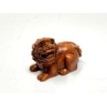 A carved hardwood netsuke - Lion