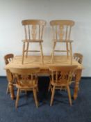 A pine farmhouse kitchen table together with a set of six chairs