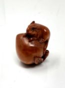 A carved hardwood netsuke - Rat on peach