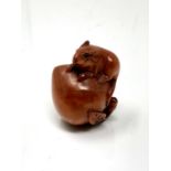 A carved hardwood netsuke - Rat on peach