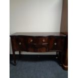 A Regency style serpentine fronted sideboard on raised legs