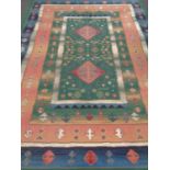 A machine made eastern design carpet on green ground 320 x 240 cm