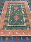 A machine made eastern design carpet on green ground 320 x 240 cm