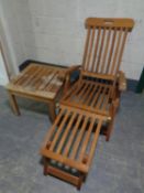 A folding teak garden lounger with foot rest together with matching coffee table